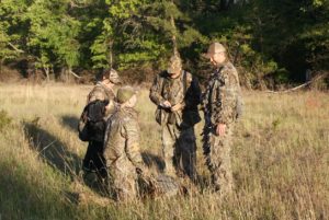 group of hunters standing around a turkey