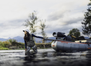 woman pulling a raft into the water
