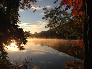 Pennsylvania's Juniata River, a tributary to the Chesapeake Bay, at sunset through the trees.